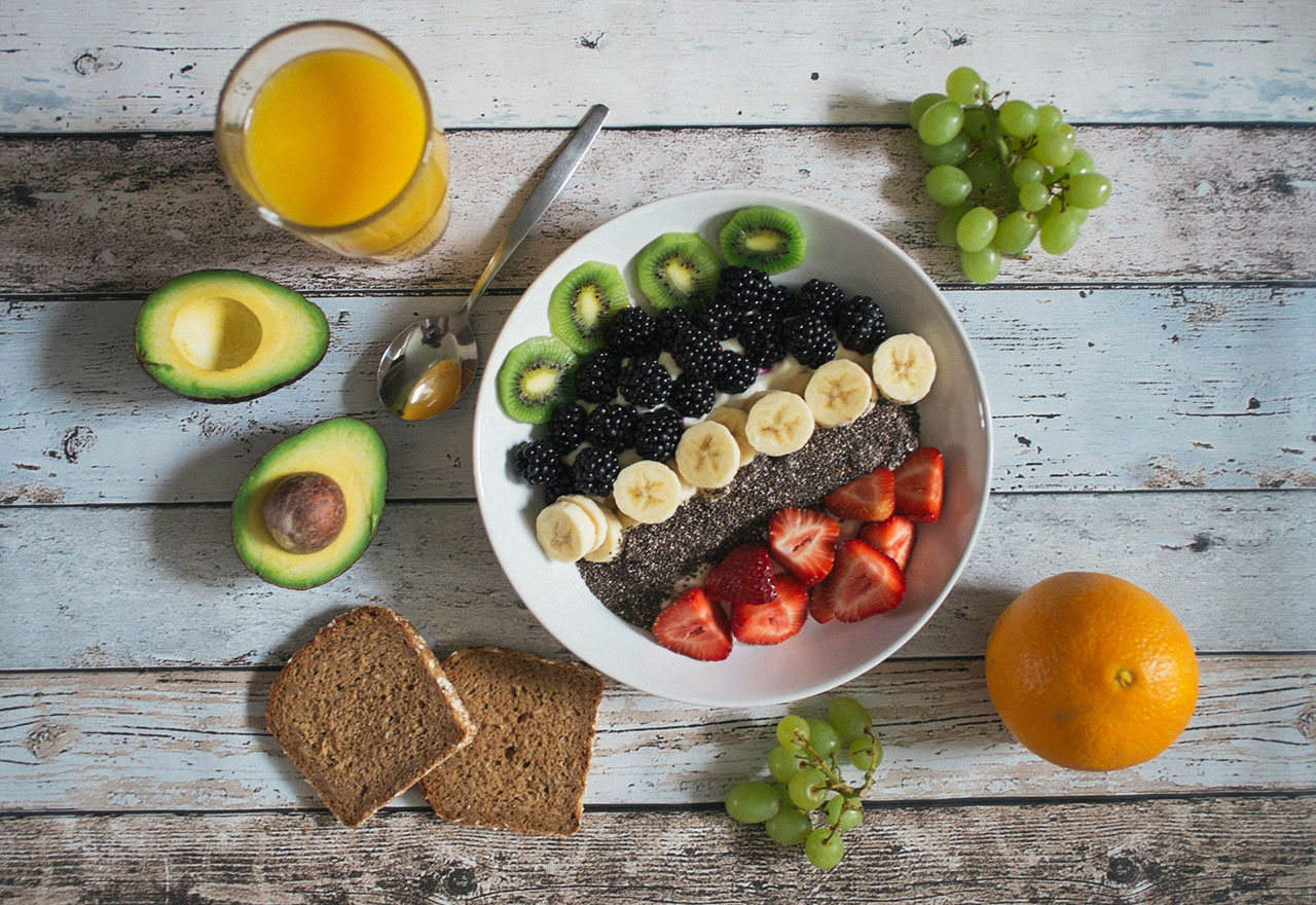 frutas, pães e suco em cima de uma mesa